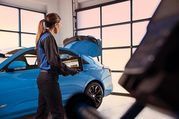 image of a person holding a car part and putting a thumbs up